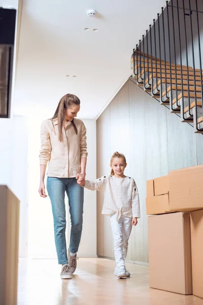 Mère heureuse tenant la main avec sa fille dans une nouvelle maison — Photo de stock