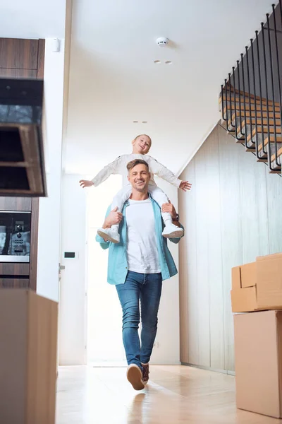 Happy father carrying on neck cheerful daughter in new home — Stock Photo