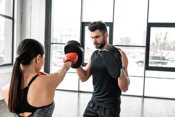 Joven pareja atlética boxeo y entrenamiento juntos en el gimnasio - foto de stock