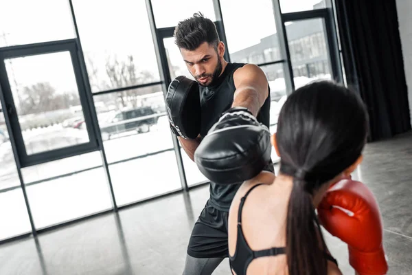 Atlético joven hombre y mujer entrenamiento y boxeo en el gimnasio - foto de stock