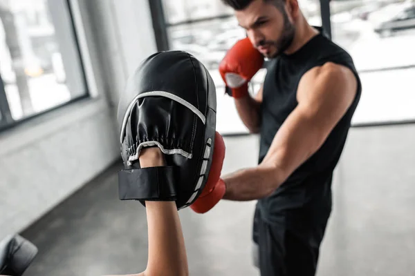 Partial view of sportswoman and male boxer in boxing gloves training together in gym — Stock Photo