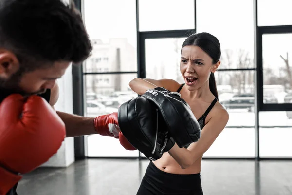 Recortado disparo de joven pareja de boxeo y entrenamiento en el gimnasio - foto de stock