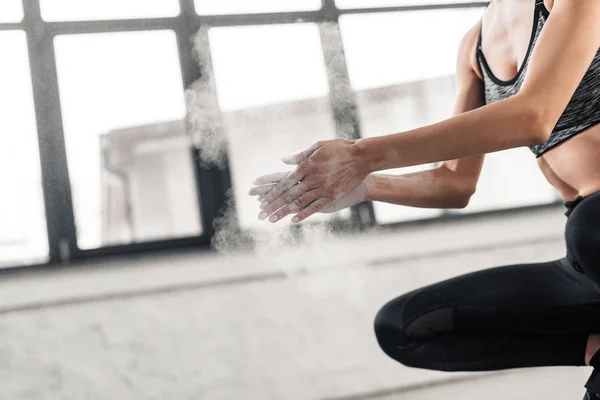 Plan recadré de jeune sportive appliquant de la poudre de talc sur les mains dans la salle de gym — Photo de stock