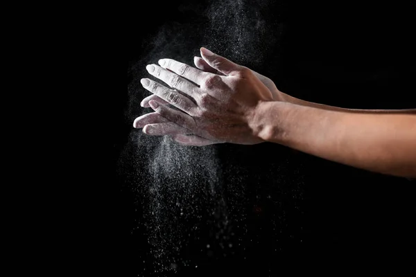Primo piano vista parziale della sportiva che applica talco in polvere sulle mani isolate sul nero — Foto stock