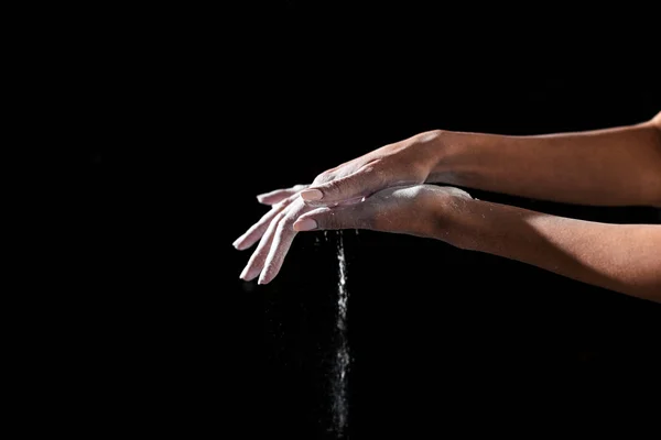 Tiro recortado de la deportista aplicando talco en polvo en las manos aisladas en negro - foto de stock