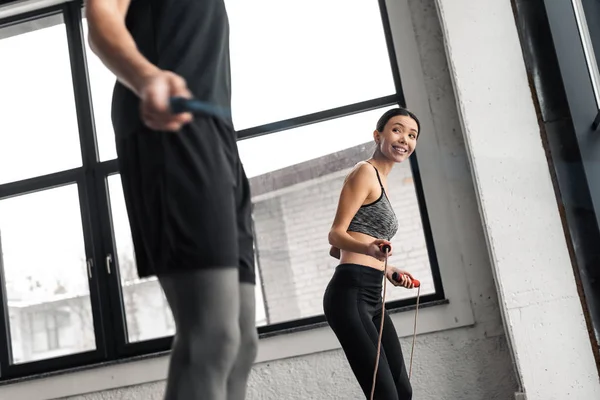 Corte tiro de jovem casal exercício com pulando cordas no ginásio — Fotografia de Stock
