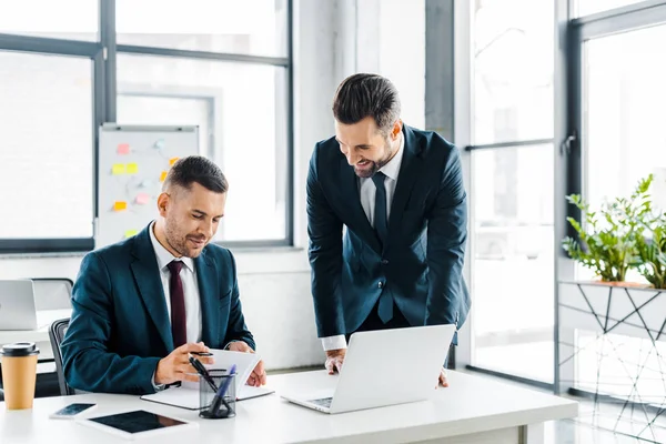 Gutaussehender Geschäftsmann schaut Mitarbeiter in modernem Büro an — Stockfoto