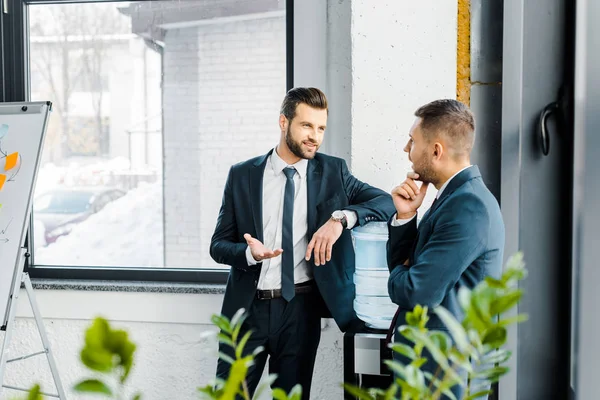 Enfoque selectivo del hombre de negocios teniendo discusión con su compañero de trabajo en la oficina moderna - foto de stock