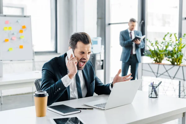 Selective focus of handsome businessman yelling in modern office — Stock Photo