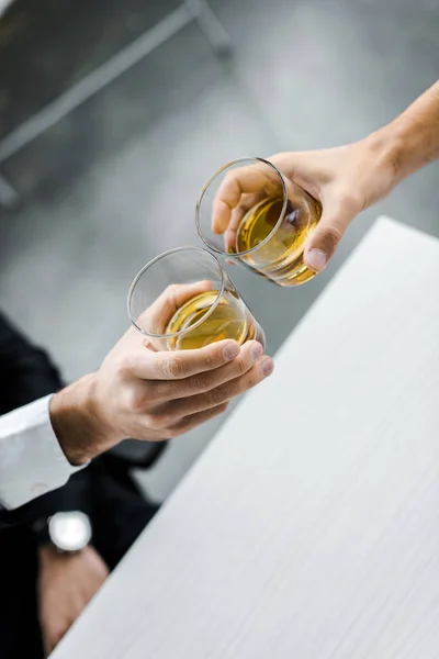 Selective focus of men toasting glasses of whiskey — Stock Photo