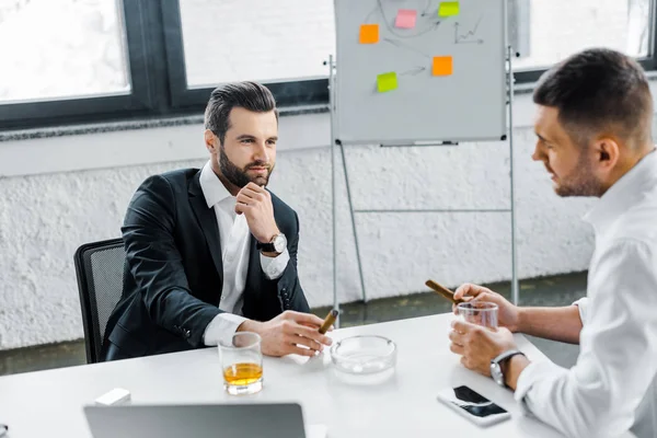 Businessmen in formal wear smoking cuban cigars in modern office — Stock Photo