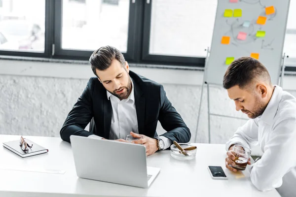 Hombres de negocios cansados teniendo discusión en la oficina moderna - foto de stock