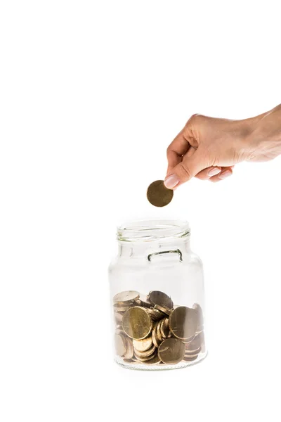 Vista recortada de la mujer tomando moneda de oro de frasco de vidrio aislado en blanco - foto de stock