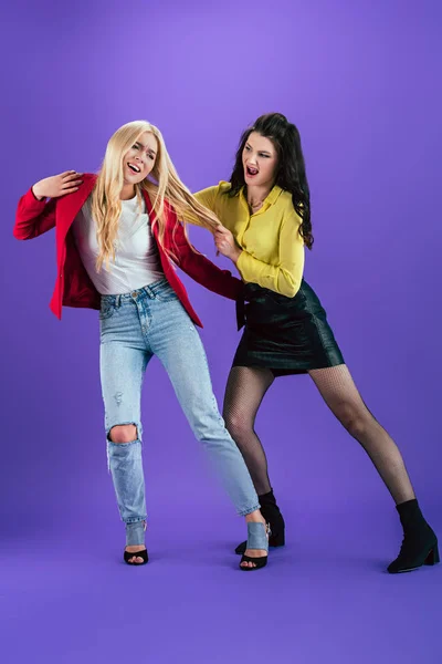 Aggressive girls yelling and fighting on purple background — Stock Photo