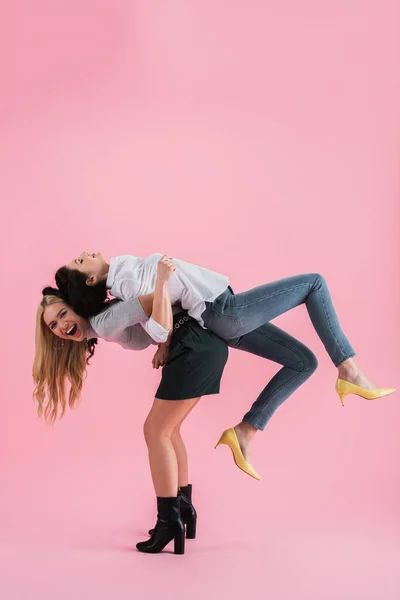 Estúdio tiro de garotas rindo brincando no fundo rosa — Fotografia de Stock