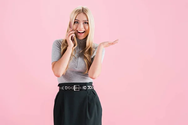 Schöne fröhliche Frau gestikuliert und spricht auf dem Smartphone, isoliert auf rosa — Stockfoto