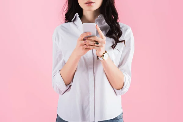 Vue recadrée de la femme en utilisant smartphone isolé sur rose — Photo de stock