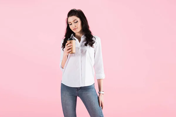 Donna attraente che tiene il caffè per andare, isolato su rosa — Foto stock