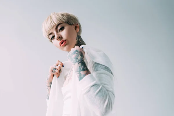 Blonde fille avec tatouages debout isolé sur gris — Photo de stock