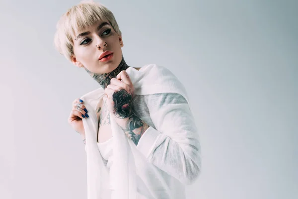 Femme confiante avec des tatouages debout isolé sur gris — Photo de stock