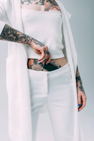 Cropped view of woman with tattoos holding audio cassette isolated on grey — Stock Photo