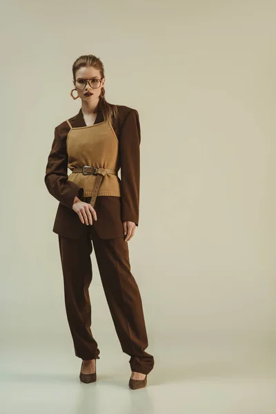 Attractive girl posing in trendy retro clothing on beige — Stock Photo