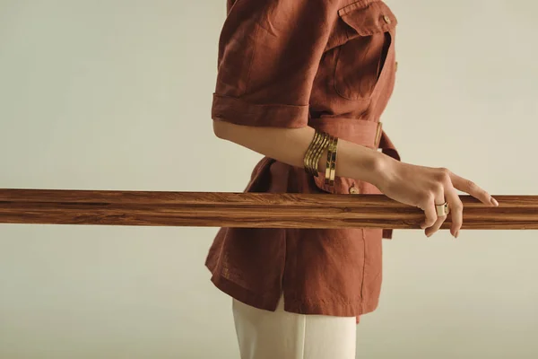 Vista ritagliata di donna elegante in posa con grande telaio in legno isolato su beige — Foto stock