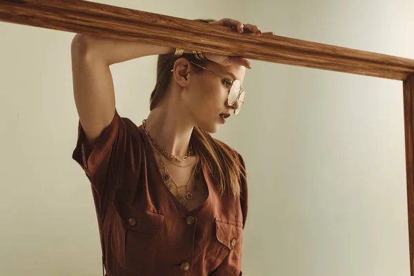 Красивая стильная девушка позирует с большой деревянной рамой изолированы на бежевый — стоковое фото