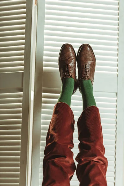 Vista cortada de pernas em sapatos de couro elegantes perto da tela dobrável — Fotografia de Stock