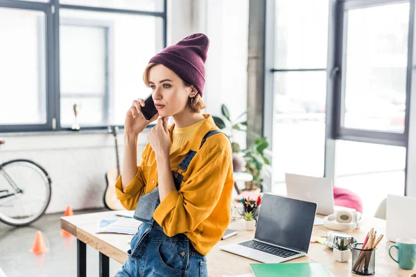 Giovane femmina è specialista parlando su smartphone vicino a scrivania di computer in ufficio loft — Foto stock