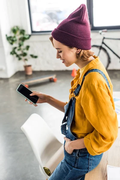 Belle fille en vêtements décontractés en utilisant smartphone avec écran blanc — Photo de stock