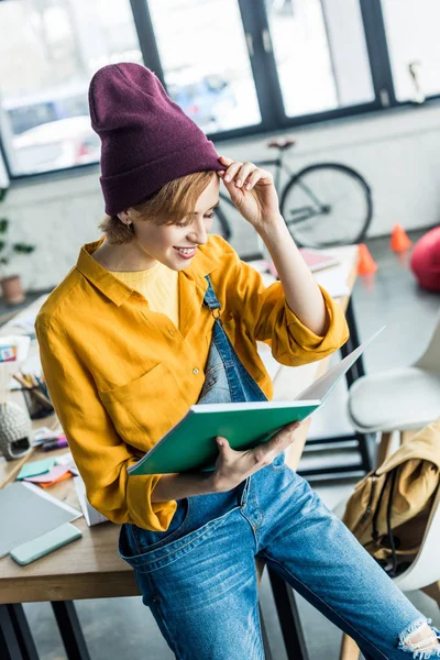 Красивая улыбающаяся дизайнер держит ноутбук в лофт-офисе — стоковое фото