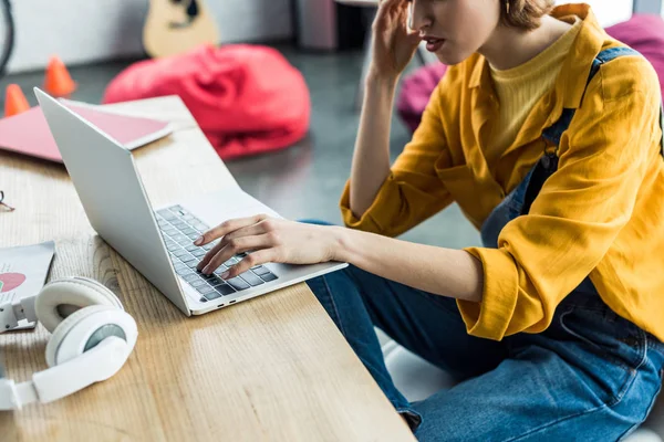 Cropped view of young female it specialist using laptop in loft office — Stock Photo