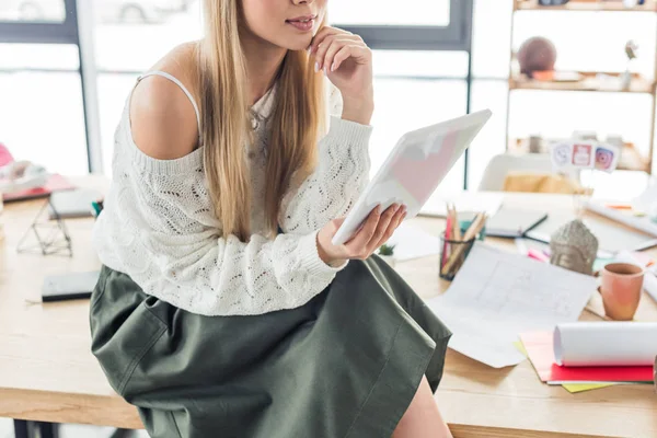 Vue recadrée de femme architecte assise sur la table avec des plans et en utilisant une tablette numérique dans le bureau loft — Photo de stock