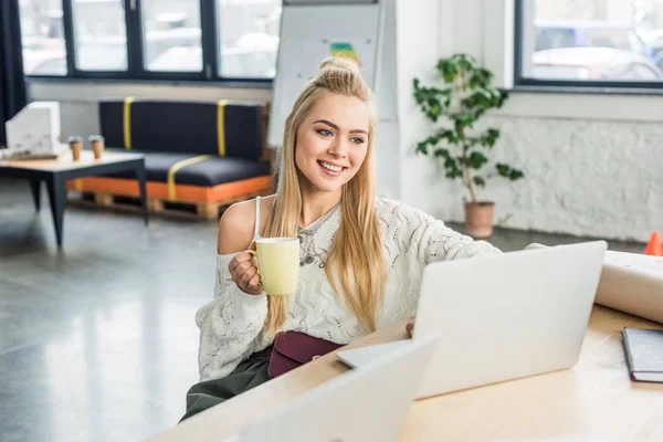 Mulher de negócios casual sentado na mesa do computador com xícara de café no escritório loft — Fotografia de Stock
