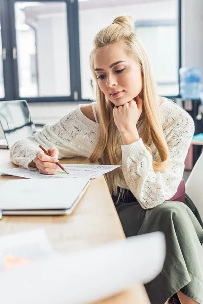 Beautiful female architect working on blueprint in loft office — Stock Photo