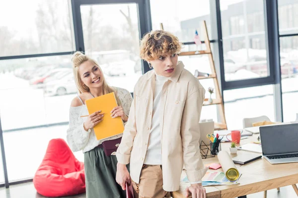 Female and male architects with notebook in loft office — Stock Photo