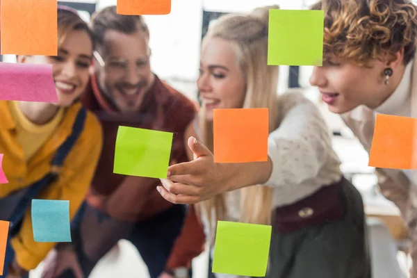 Gelegenheitsunternehmerinnen und -unternehmer durch Glasfenster mit bunten Haftnotizen im Büro — Stockfoto