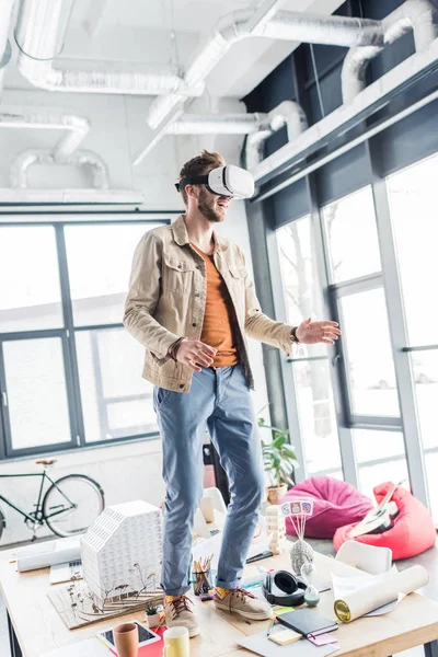 Aufgeregter männlicher Designer gestikuliert mit den Händen, während er Virtual-Reality-Erfahrung im Loft-Büro hat — Stockfoto