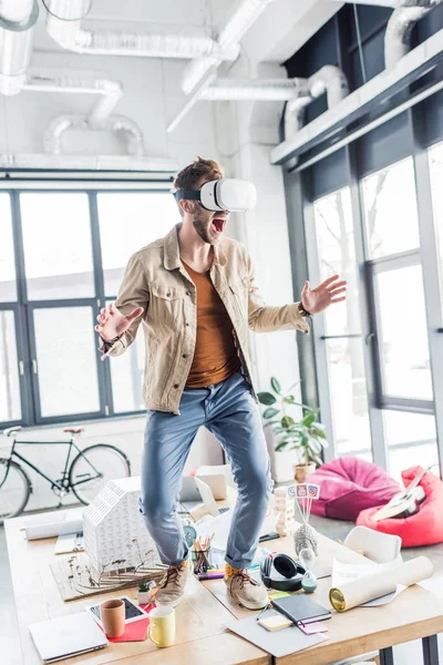 Архитектор-мужчина кричит и жестикулирует руками, имея опыт виртуальной реальности в офисе на чердаке — стоковое фото