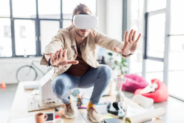 Selektiver Fokus männlicher Designer, die mit den Händen gestikulieren, während sie Virtual-Reality-Erfahrung im Loft-Büro haben — Stockfoto