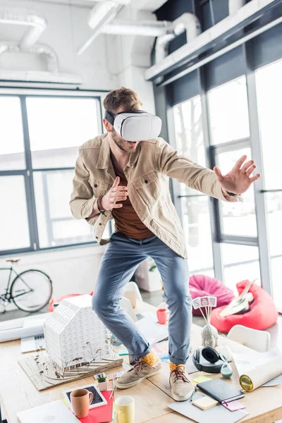 Architecte masculin surpris geste avec les mains tout en ayant une expérience de réalité virtuelle dans le bureau loft — Photo de stock