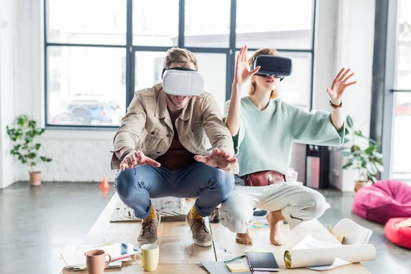 Aufgeregte Architektinnen und Architekten gestikulieren mit den Händen, während sie Virtual-Reality-Erfahrung im Loft-Büro haben — Stockfoto