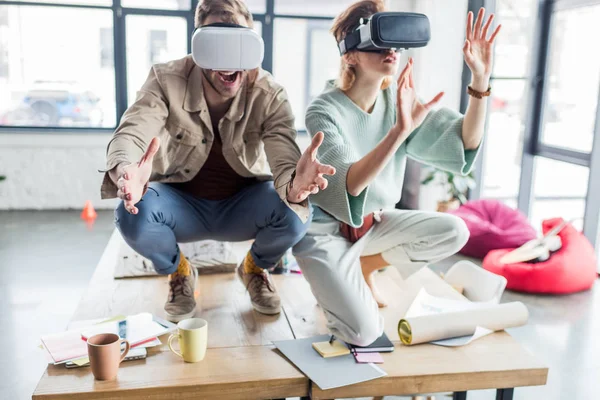 Foco seletivo de arquitetos femininos e masculinos excitados gesticular com as mãos, tendo experiência de realidade virtual no escritório loft — Fotografia de Stock