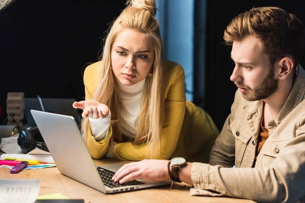 Female and male it specialists using laptop in office — Stock Photo