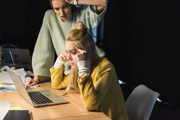 Hermosa mujer confundida que especialistas utilizando el ordenador portátil en la oficina - foto de stock