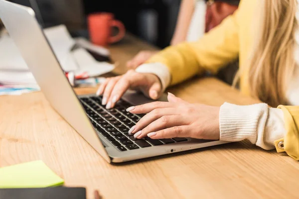 Visão cortada de fêmea especialista em que usando laptop no escritório — Fotografia de Stock