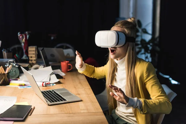 Збуджена випадкова бізнес-леді жестикулює руками, маючи досвід віртуальної реальності за комп'ютерним столом в офісі — стокове фото