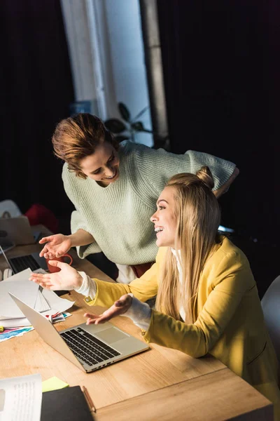 Bella femmina specialisti ridere mentre si utilizza il computer portatile in ufficio — Foto stock