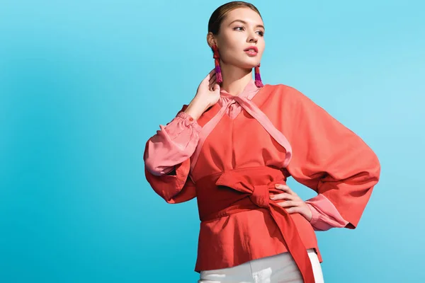 Attractive fashionable girl posing in trendy living coral clothing isolated on blue — Stock Photo